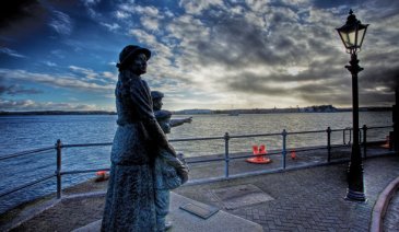 statue of woman and child beside the sea 