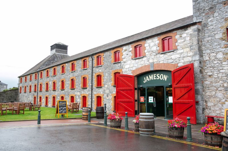 stone building with red windows and jameson on the door 