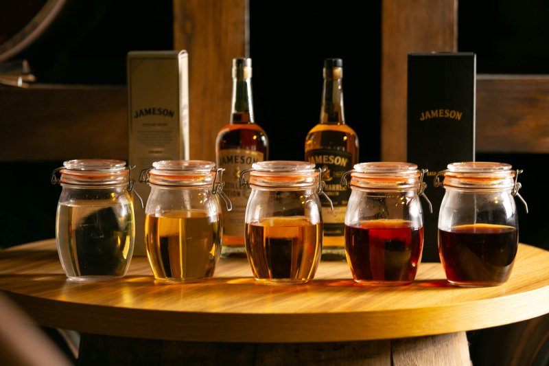 five whiskey samples in glass jars
