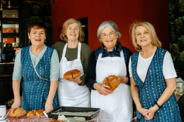 four women holding bread